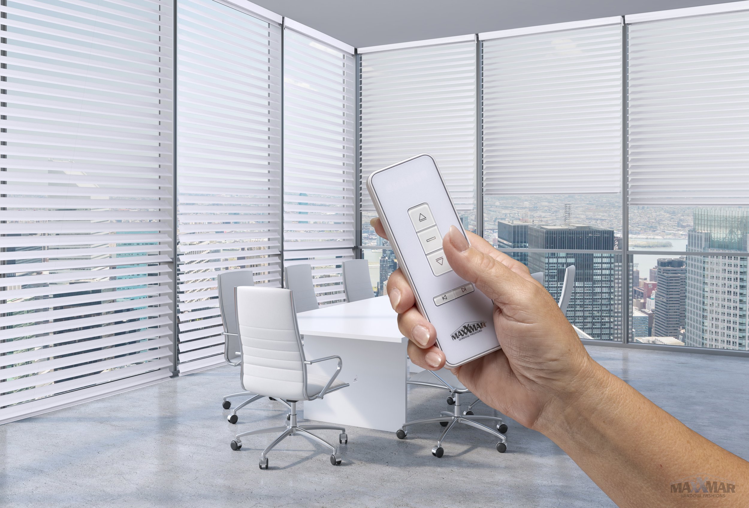 A hand holding a remote control in front of a modern office conference room with white chairs, a white table, large windows, and a city skyline view.