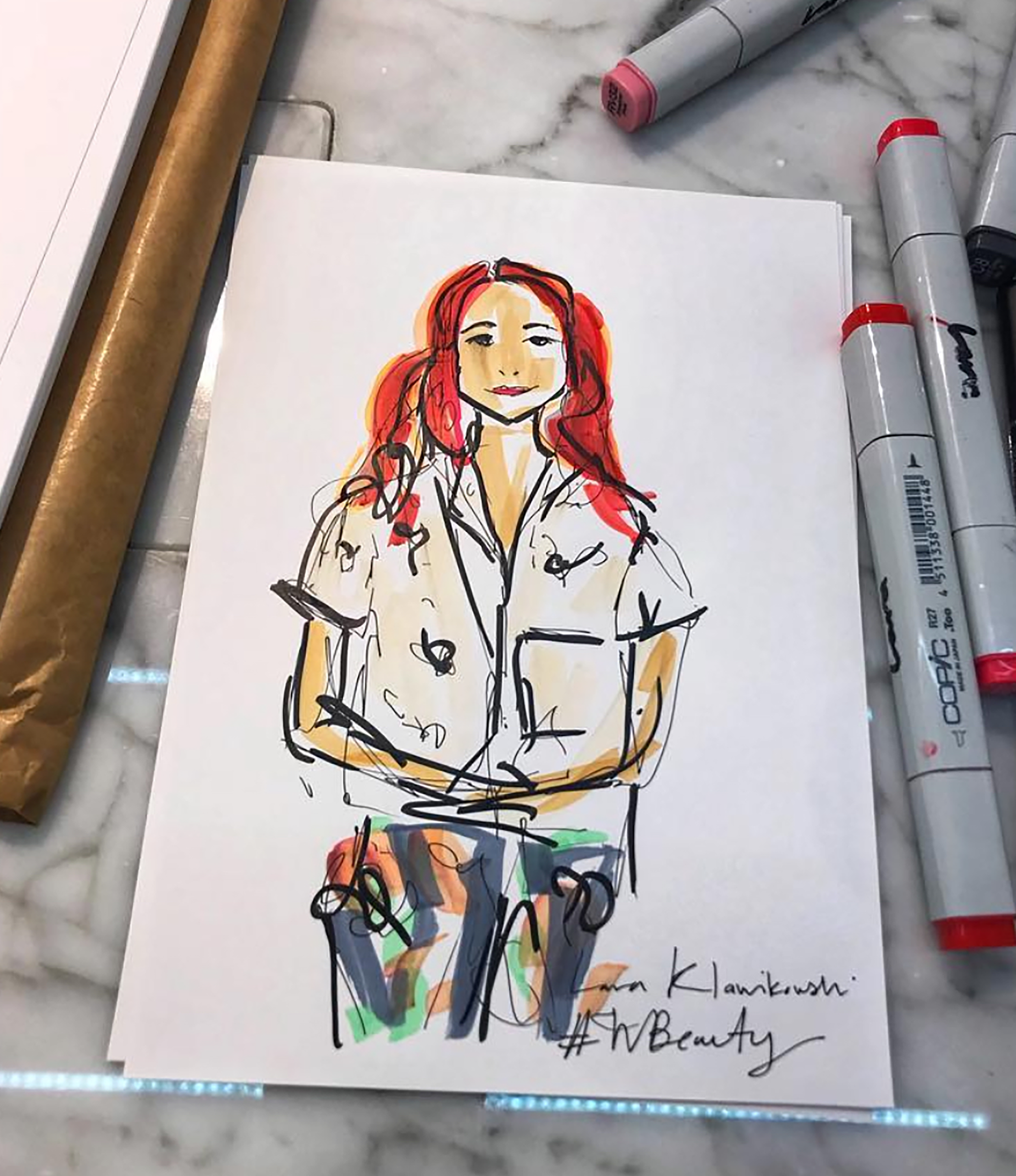 A colorful sketch of a woman with red hair, wearing a short-sleeved shirt and jeans, sitting with her arms crossed. Art supplies like markers are nearby.