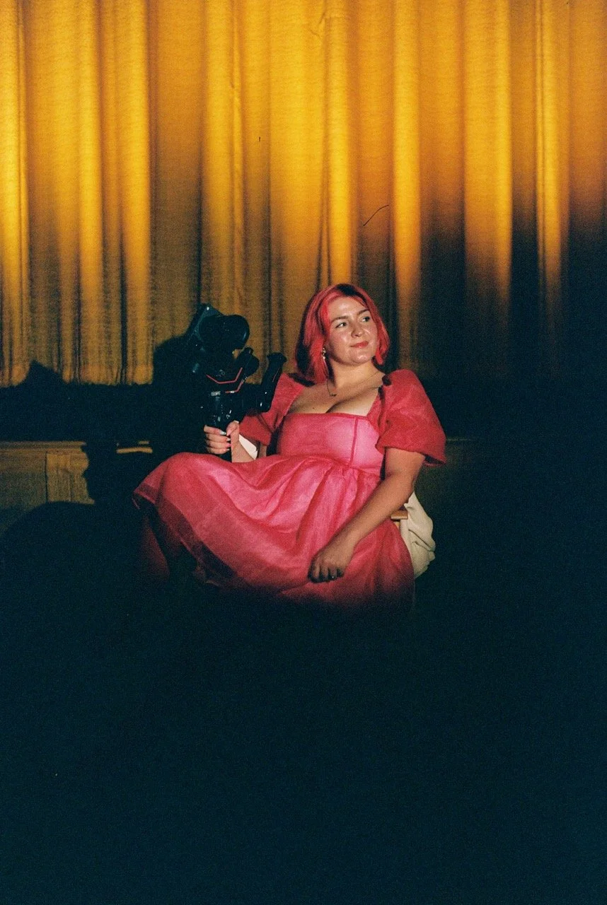 A woman with pink hair sits in front of a golden curtain, offering nostalgic documentary style cinematic wedding videography