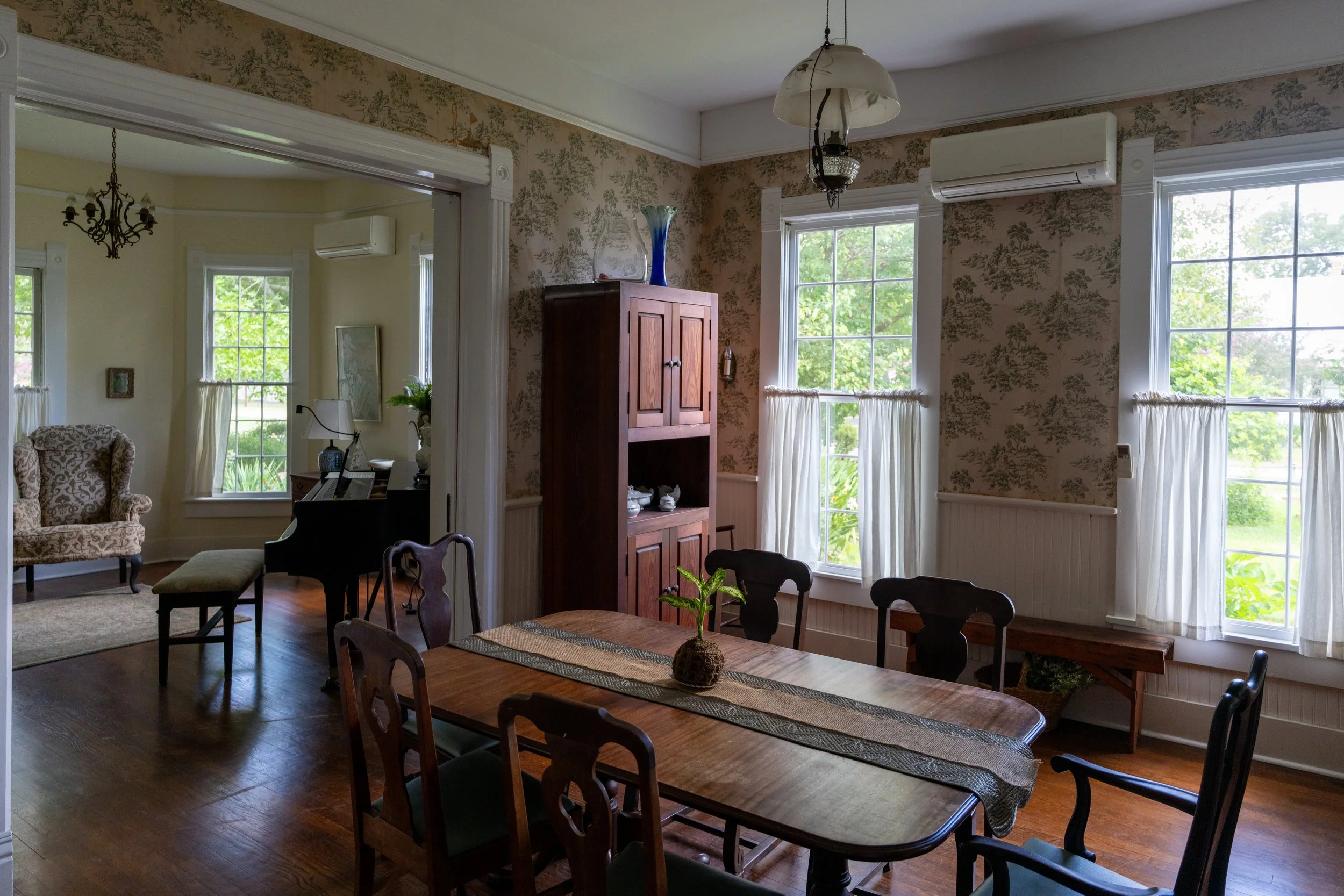 The dining room opens into the kitchen and music room. Pine cupboards contain everything you need for elegant entertaining—wine glasses, platters, and more. The table can be extended with extra leaves to comfortably seat up to 8 people.