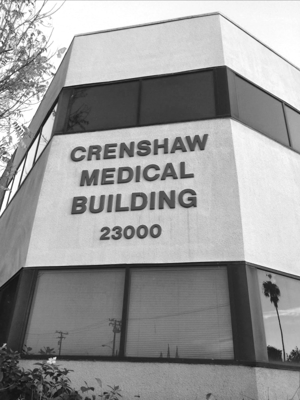 Front view of the Crenshaw Medical Building at 23000, a modern multi-story medical facility with large windows and street reflections.