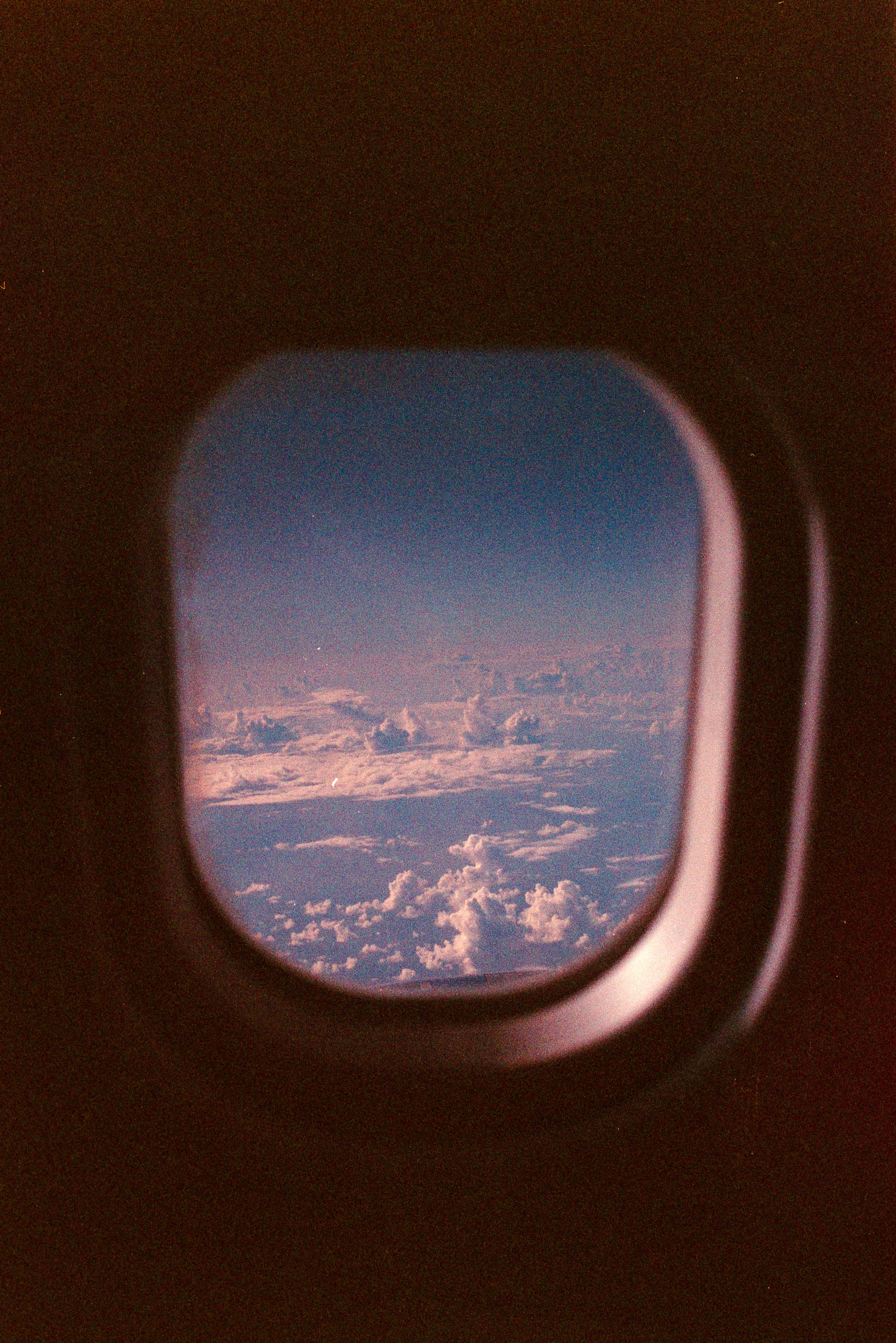 View of sky and clouds seen through an airplane window. photo by Bruno Novais