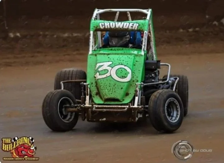 Green sprint car with the number 30 and the name Crowder on top, racing on a dirt track.