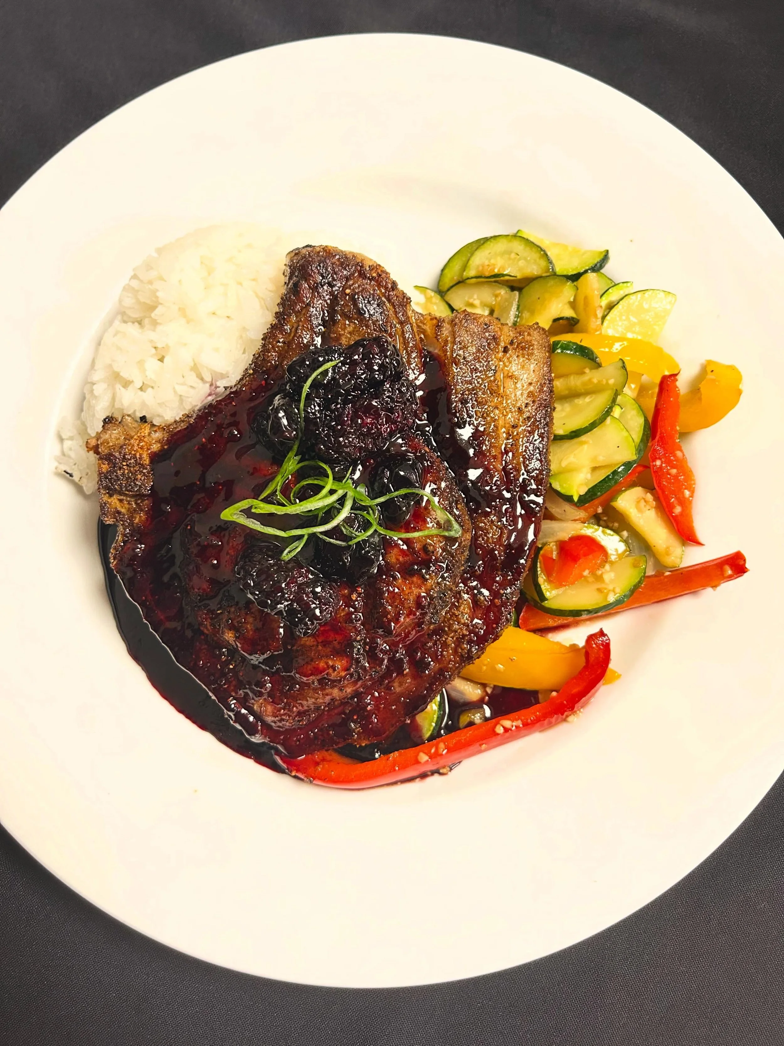 come in and see us tonight for a blackened pork chop topped with a reduction of port wine, blueberry, and blackberry. served with jasmine rice, and a medley of zucchini , mixed bell peppers, and onions! pair it with an amazing cocktail, seems like a 