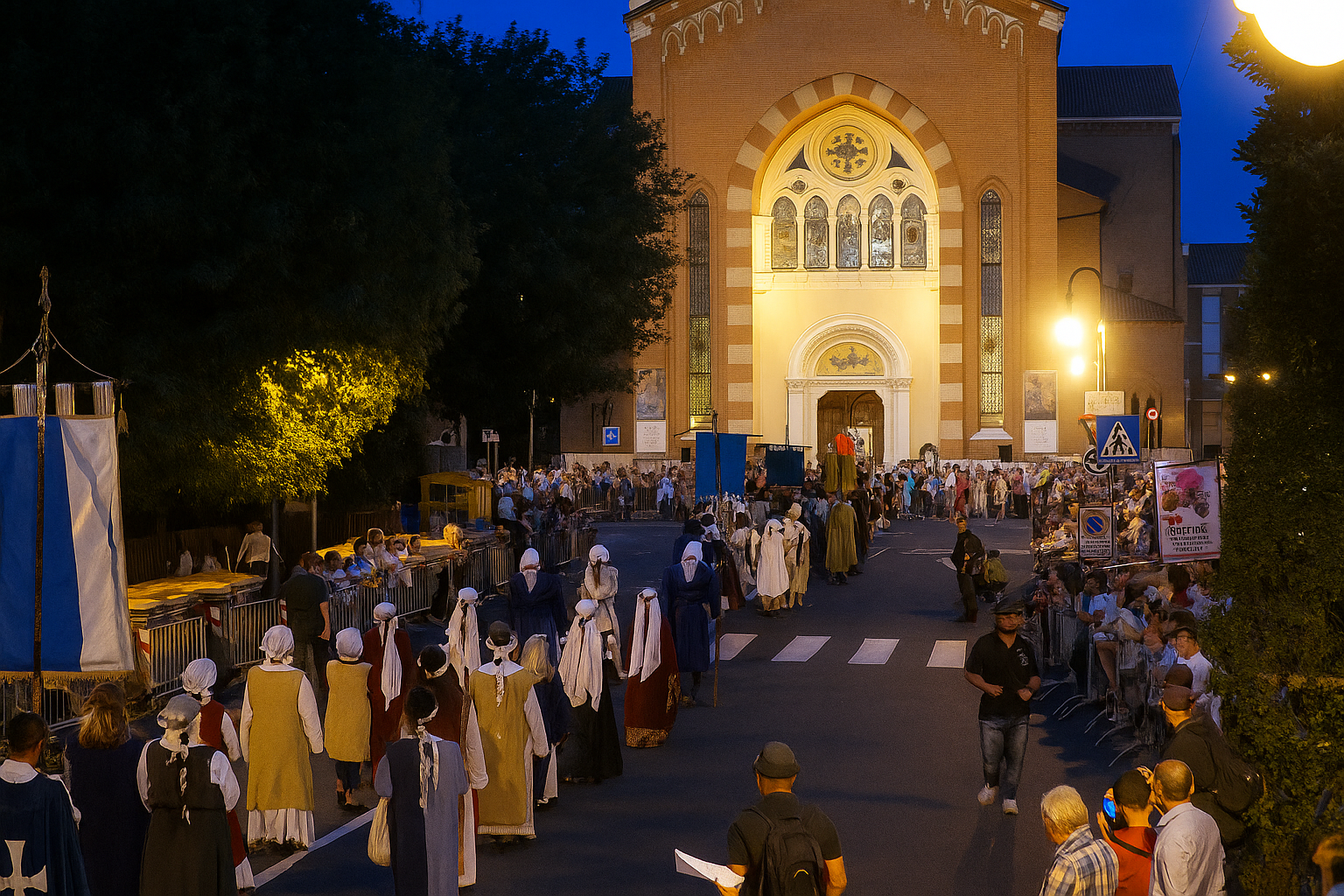 Una scena serale davanti a una chiesa con persone in abiti tradizionali che partecipano a un evento culturale o religioso. Sul lato sinistro, ci sono bancarelle e persone sedute, mentre sul lato destro, la strada è popolata da persone che camminano o osservano. La chiesa è illuminata e ha un'architettura in stile storico con grandi finestre.