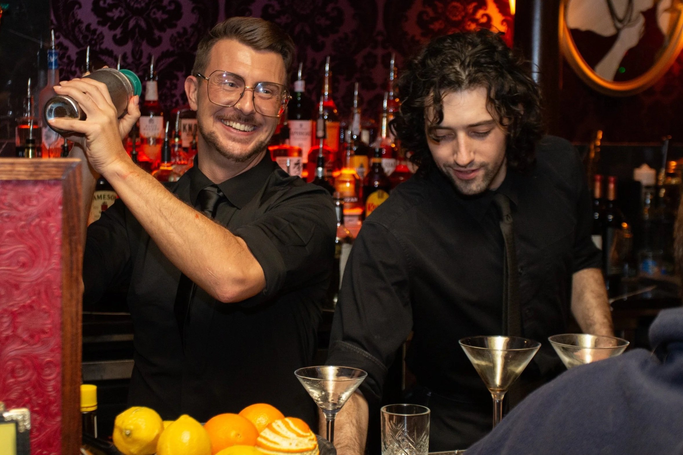 Two bartenders are making a martini