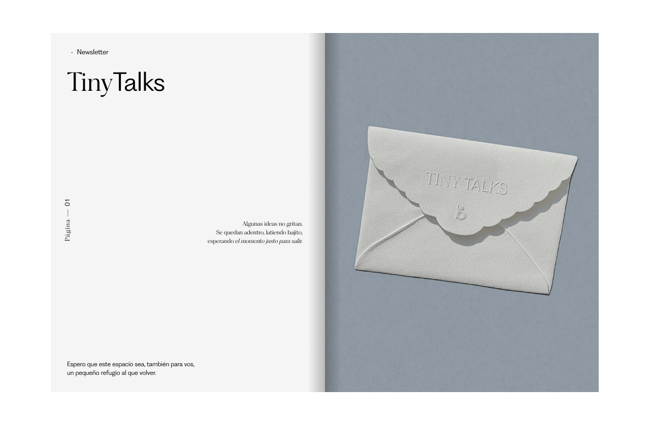 Open magazine spread with a white embossed envelope on a light grey background on the right page, and text in Spanish on the left page. The title is 'Tiny Talks' and parts of the text discuss ideas and refuge.