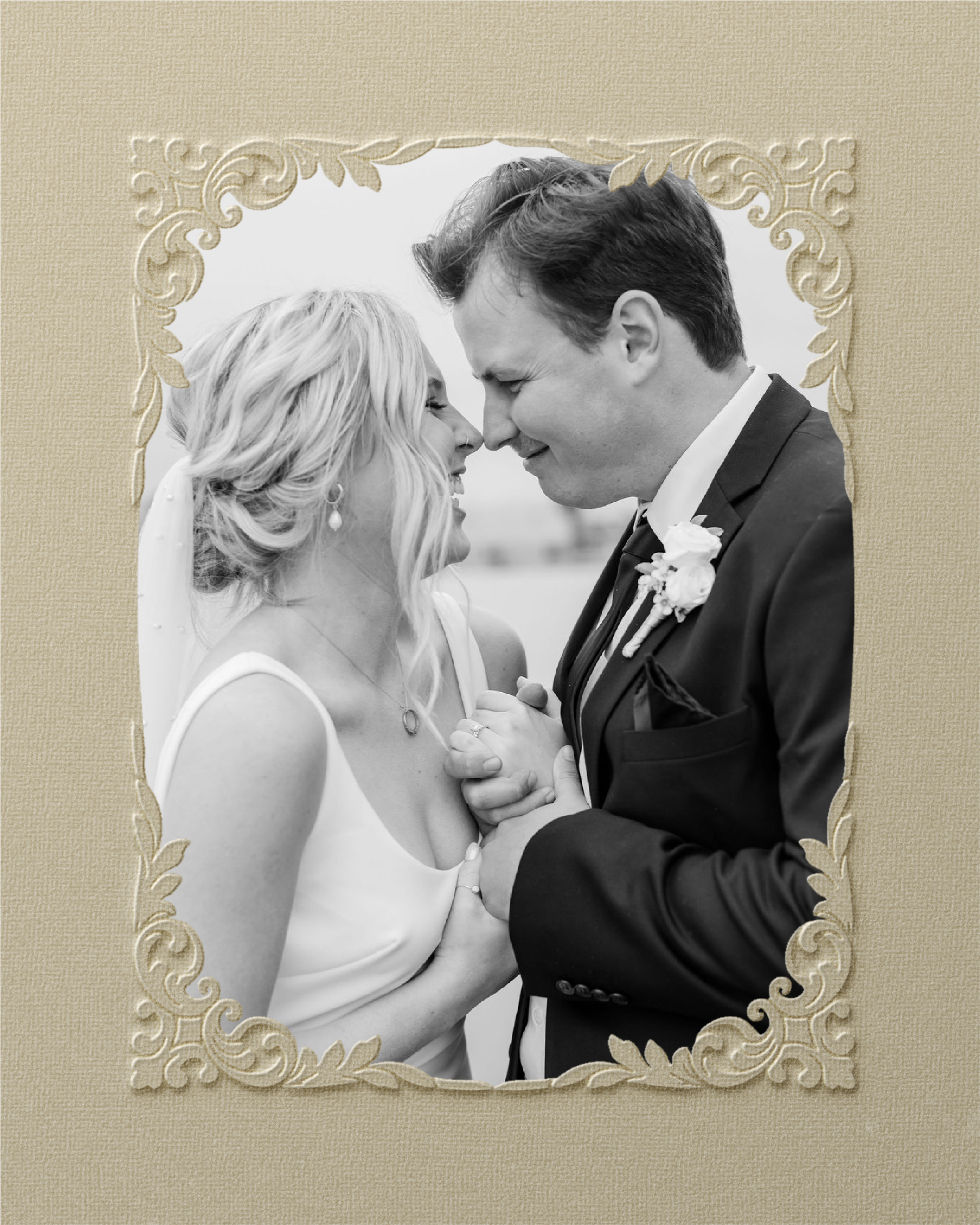 Black and white photo of a bride and groom holding hands, smiling, close together, outdoors, with decorative border.
