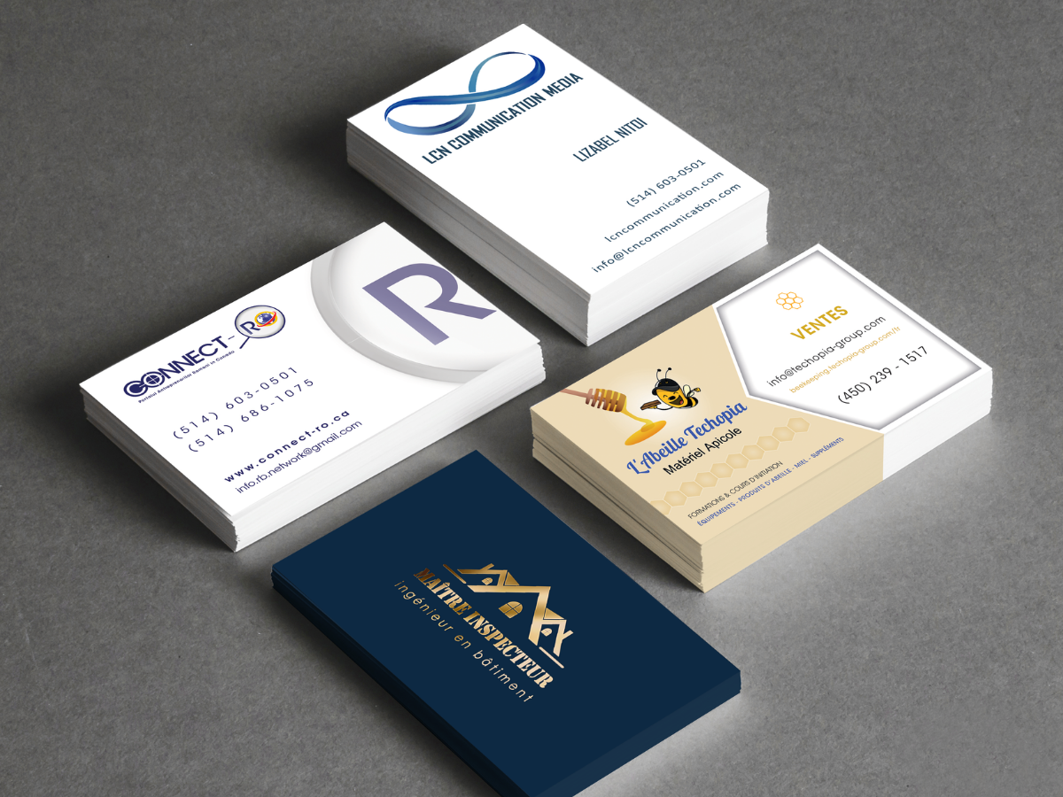 Paquet de plusieurs cartes de visite avec différents designs et logos, certains en pile, sur un fond gris.