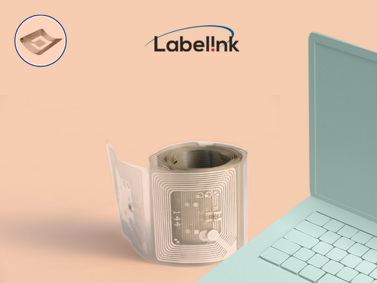 Une bobine de papier ou d'étiquette avec un ordinateur portable sur un fond beige.