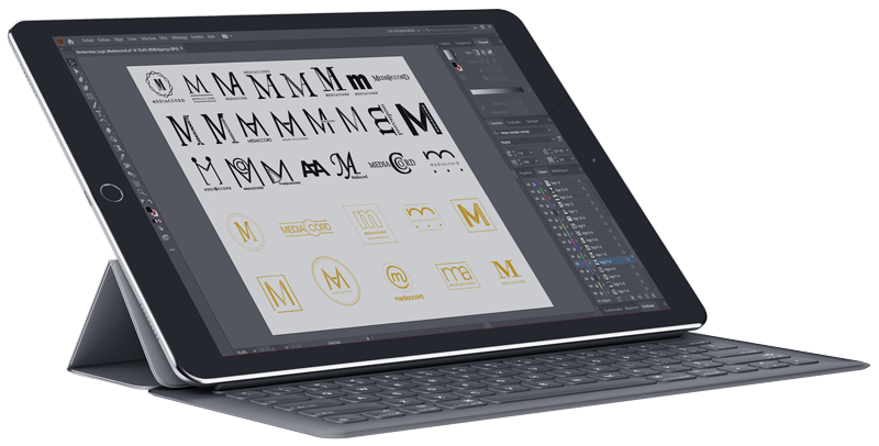 Une tablette avec un clavier montrant un logiciel de conception graphique avec différents logos.