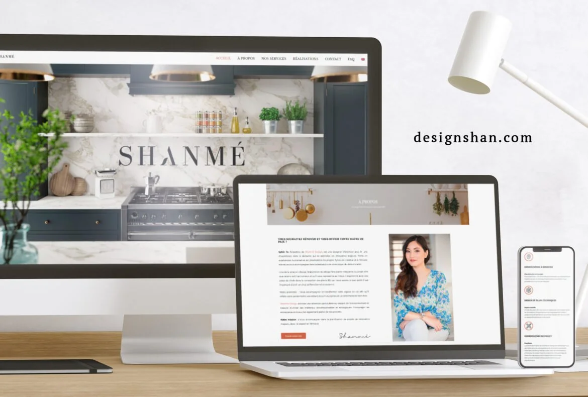 Écran d'ordinateur, ordinateur portable et téléphone affichant des sites web, bureau en bois, lampe blanche, décor minimaliste.