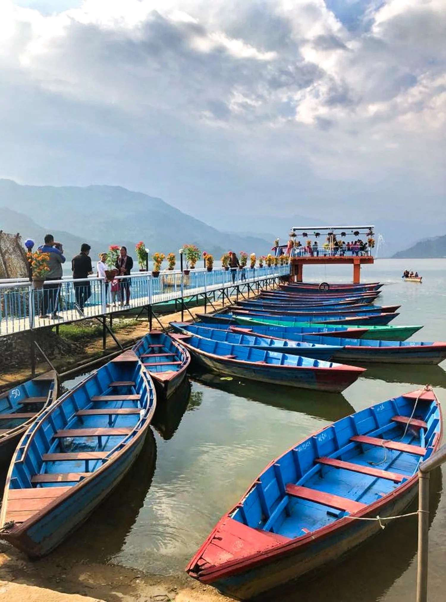 Colourful boats on Phewa Lake in Pokhara Nepal surrounded by mountains, peaceful travel photography