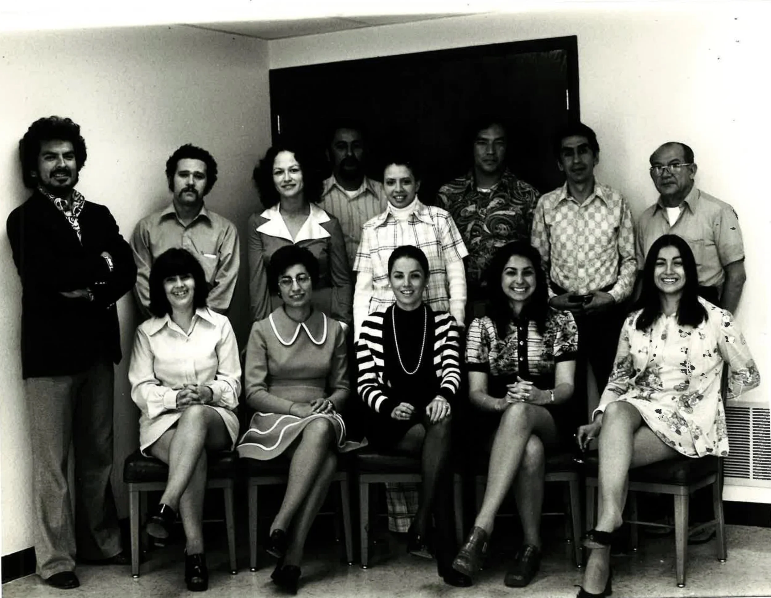 MLVS History: Black and white photo of fifteen people, with women seated in front and men standing behind them, in an indoor setting.