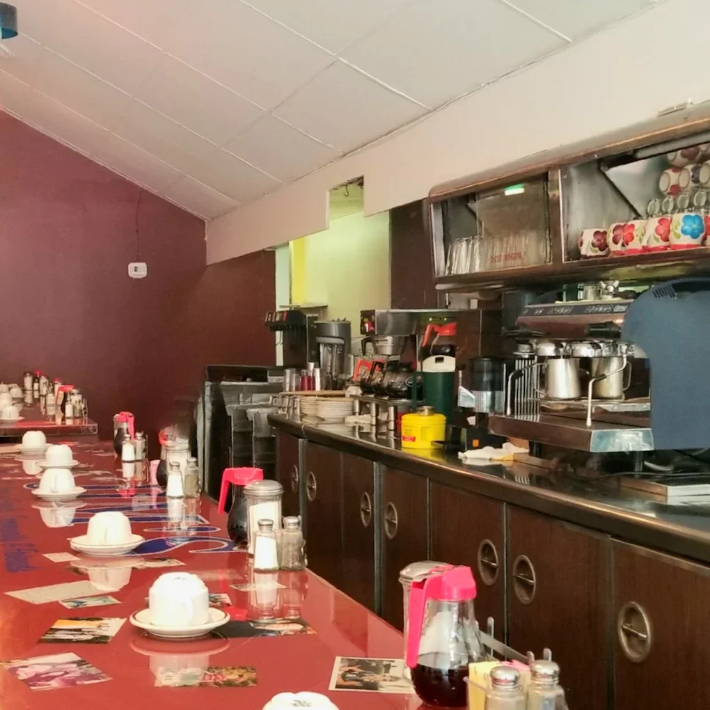 Jims By MLVS. Jims counter with cups, plates, condiments, and coffee machines