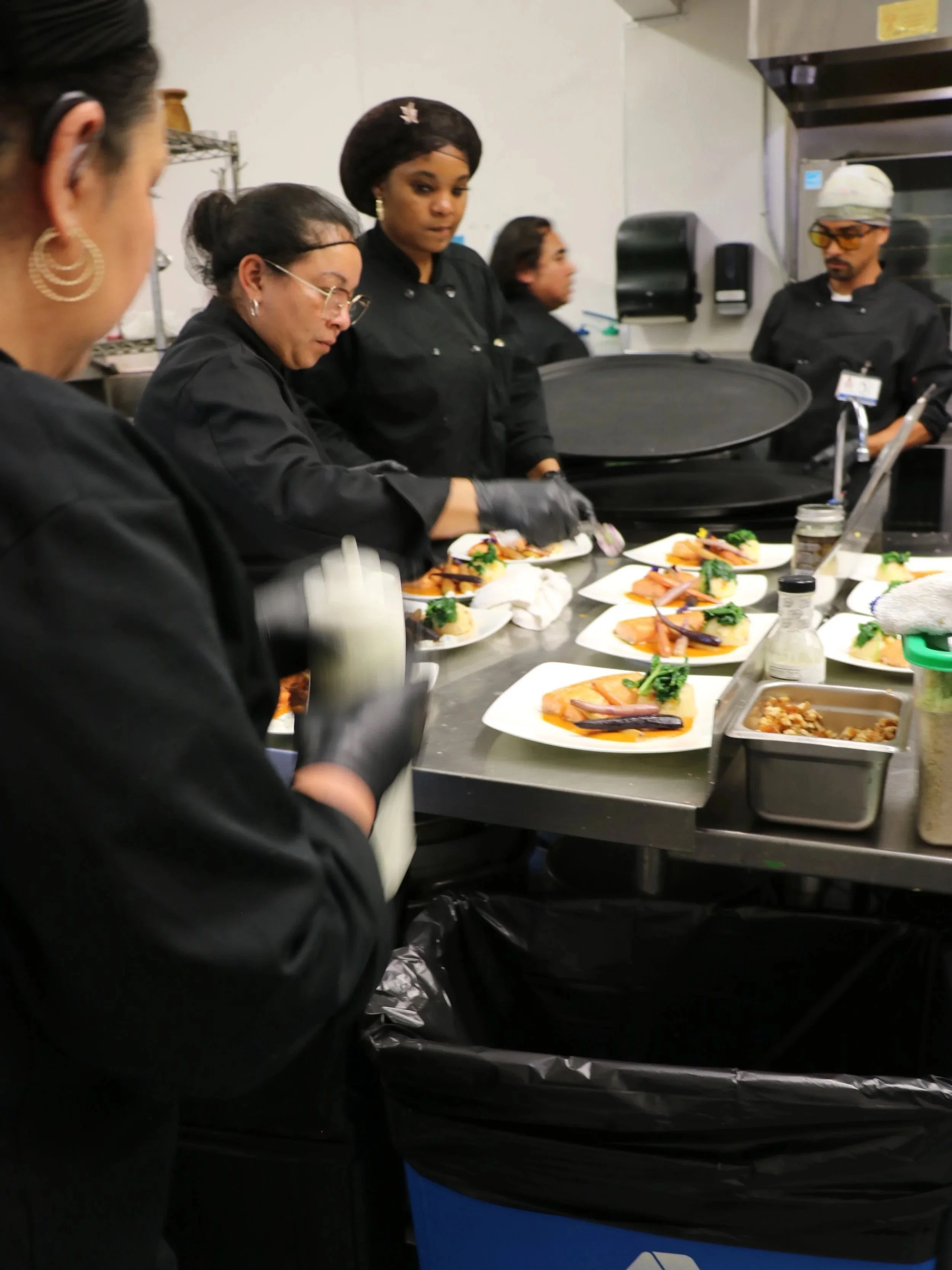 MLVS Culinary Program: Group of chefs preparing plated dishes in a commercial kitchen.