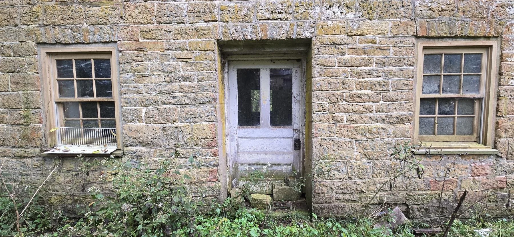  The door and two windows, with the stonework around them. 