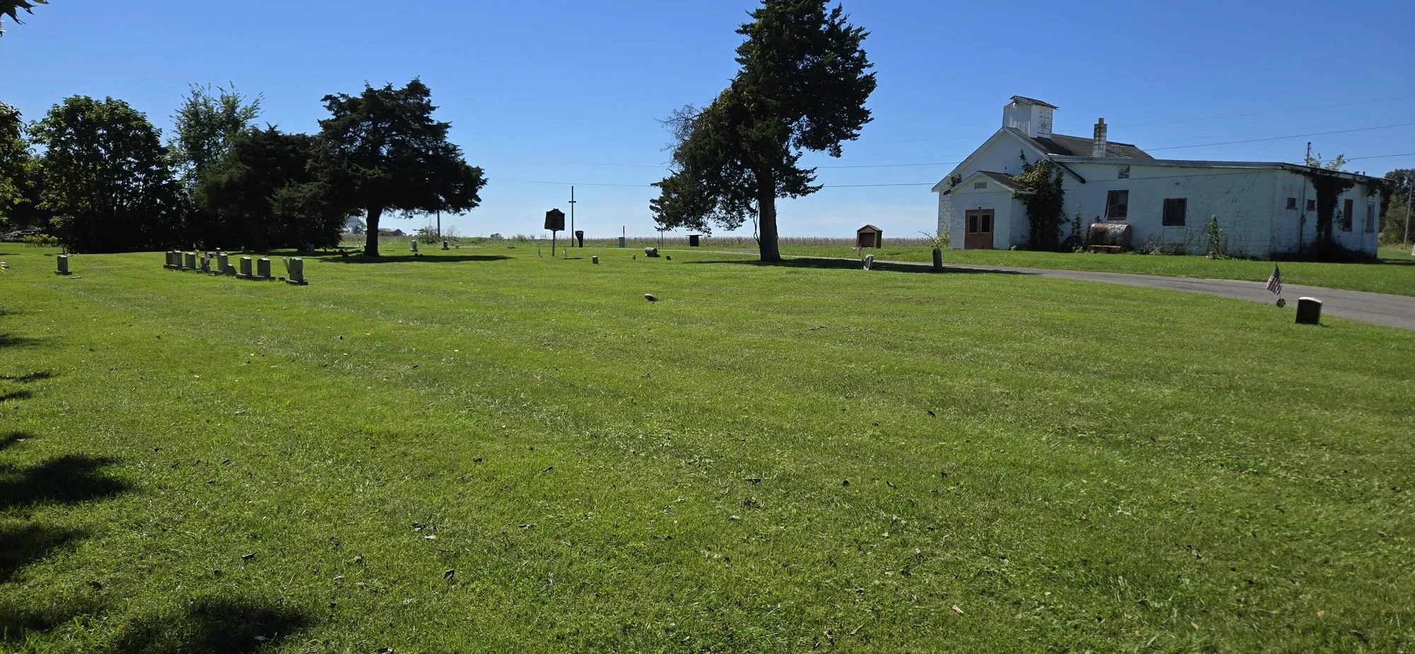 The Gist Settlement Cemetery on Gist Settlement Road in Highland County, Ohio, with Ohio Historical Marker 5-36 at center and Carthagenia Baptist Church across the road at right.