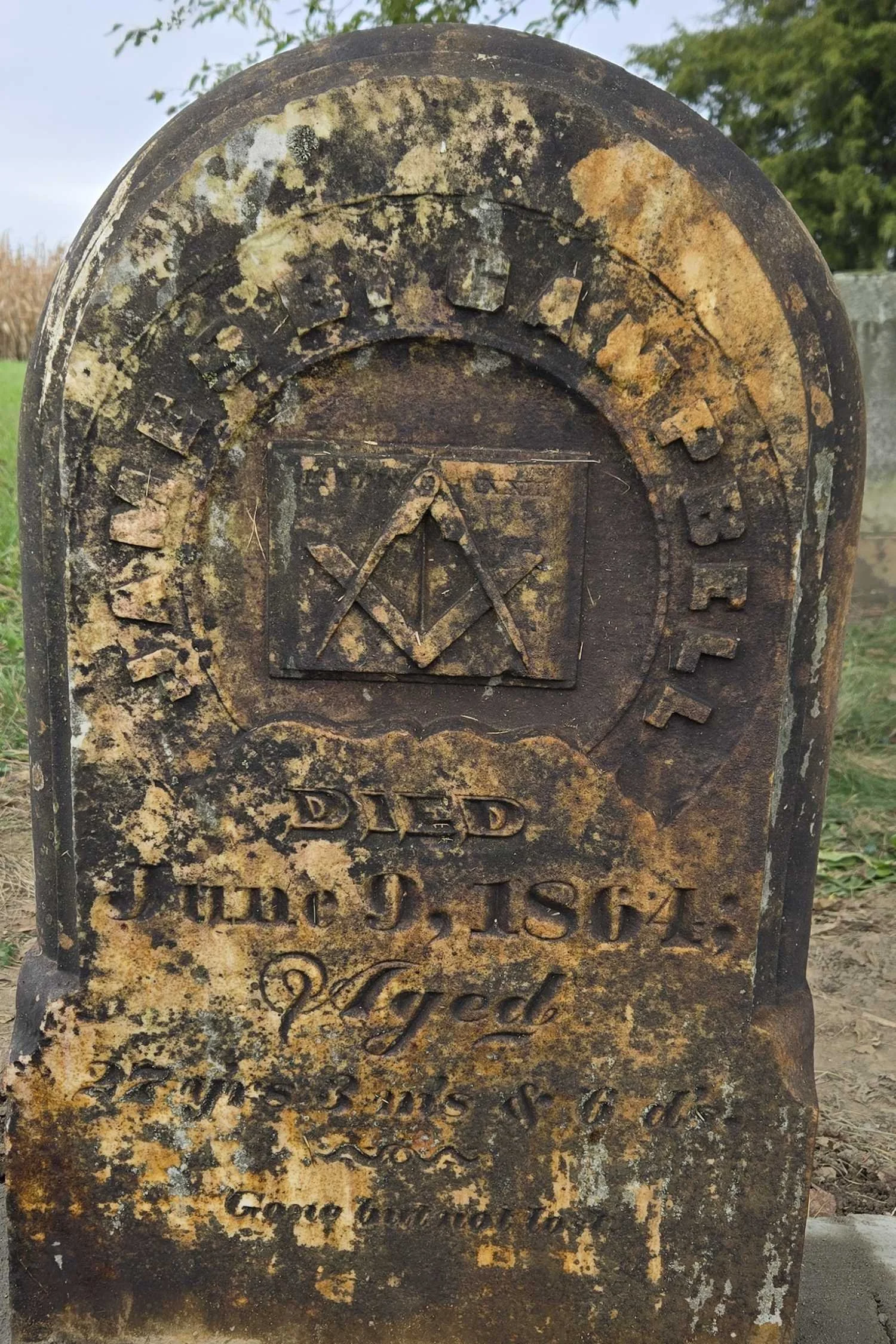 Close view of the headstone’s face: the name James B. Campbell in an arc, a carved square and compasses in a panel, and the lines Died June 9, 1864, Aged 27 years 3 months and 6 days.