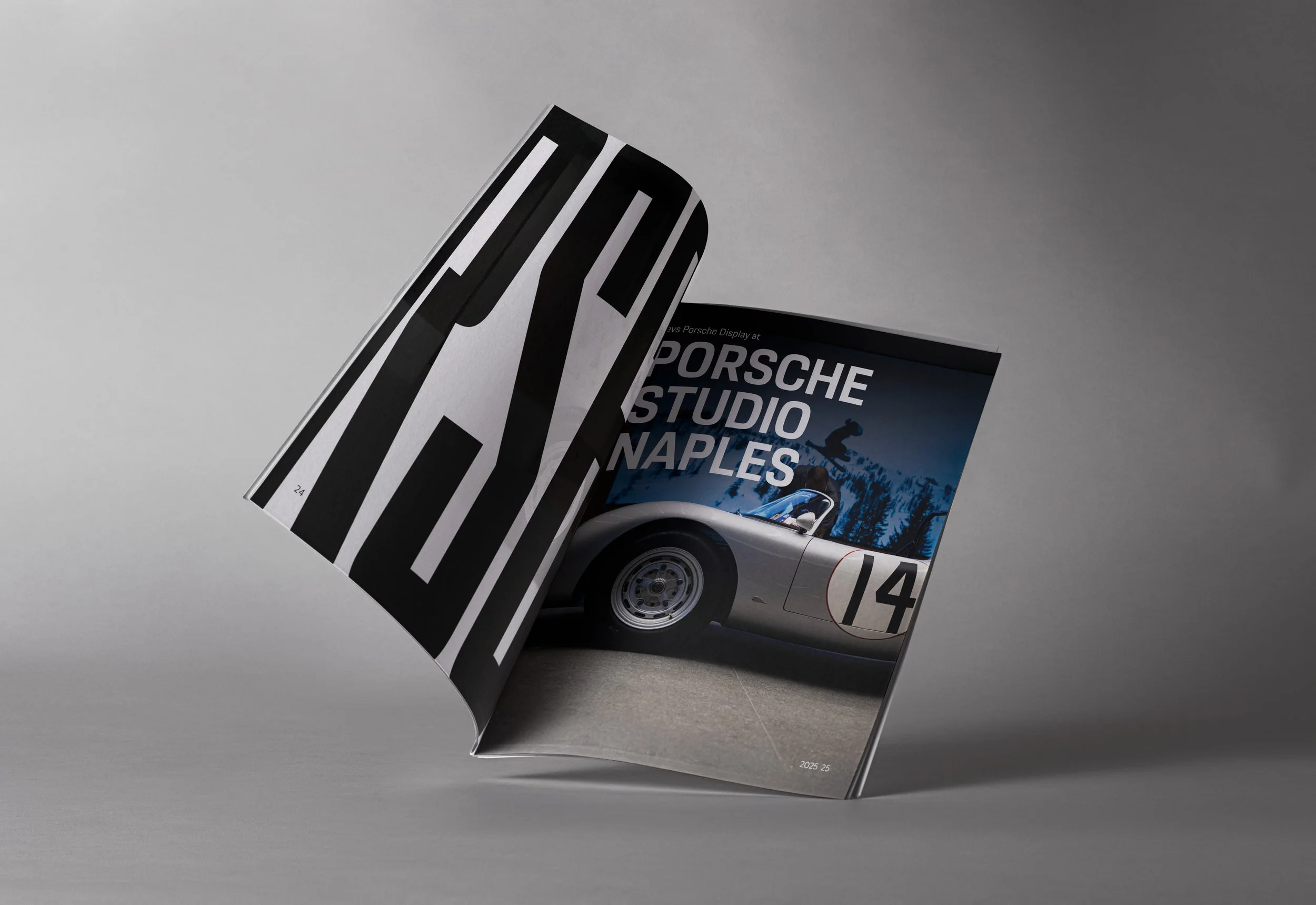 A folded magazine or brochure featuring a Porsche car and a blue mountain scene, with text about Porsche Studio Naples.