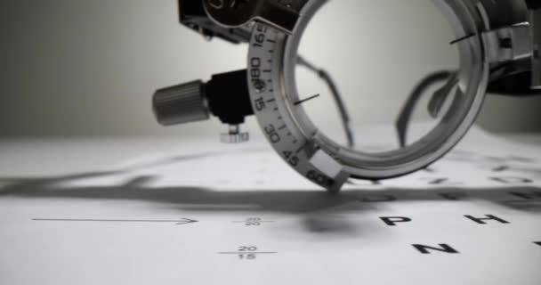 Close-up of an ophthalmic device focusing on an eye chart with letters and a spherical lens