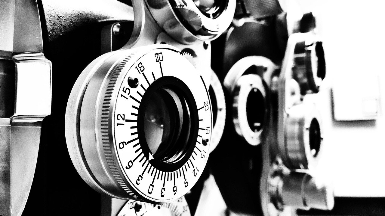 Close-up of diopter adjustment dials on a phoropter used for eye exams, with a focus on the numbered rings in black and white.
