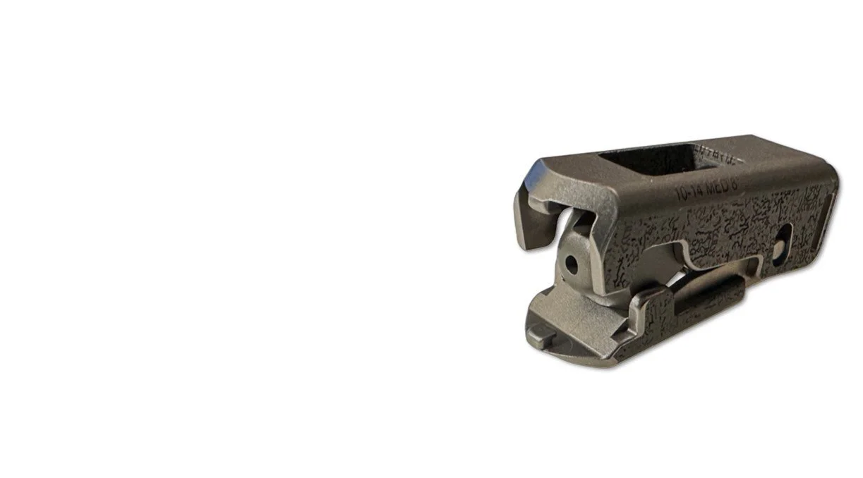 Two expandable lumbar implants with biobraille with rectangular openings, resting on a white surface, casting shadows.