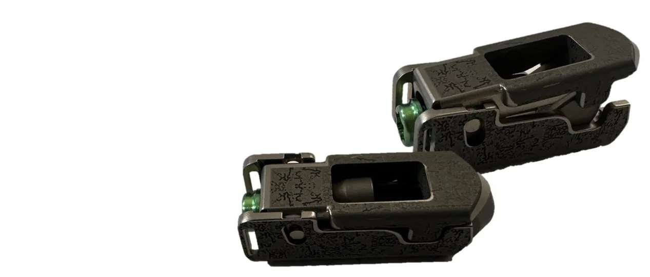 Two expandable lumbar implants with biobraille with rectangular openings, resting on a white surface, casting shadows.