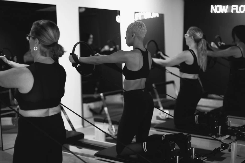 A modern building with wooden exterior panels located in a mountainous landscape with sparse vegetation and cloudy sky.