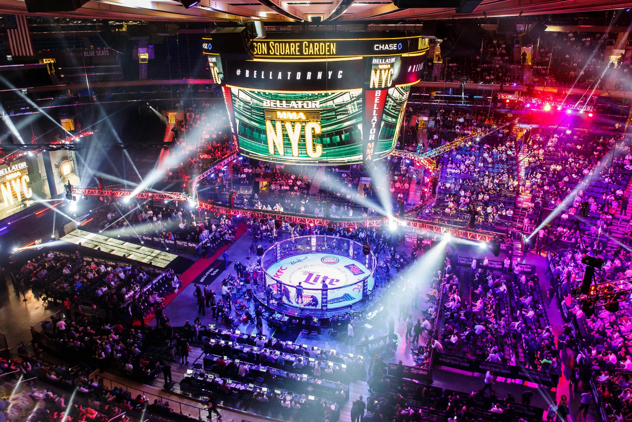 An indoor MMA fighting arena at Madison Square Garden during a Bellator event, with a center octagon, bright lighting, and a large audience seated around the ring.