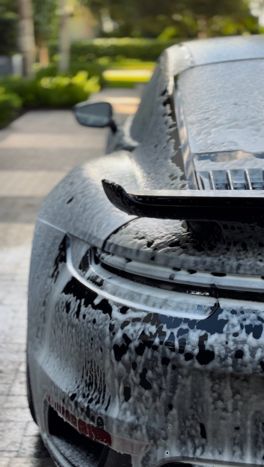 Porsche 911 rear covered in foam during pre-wash stage of mobile car detailing in Naples Florida