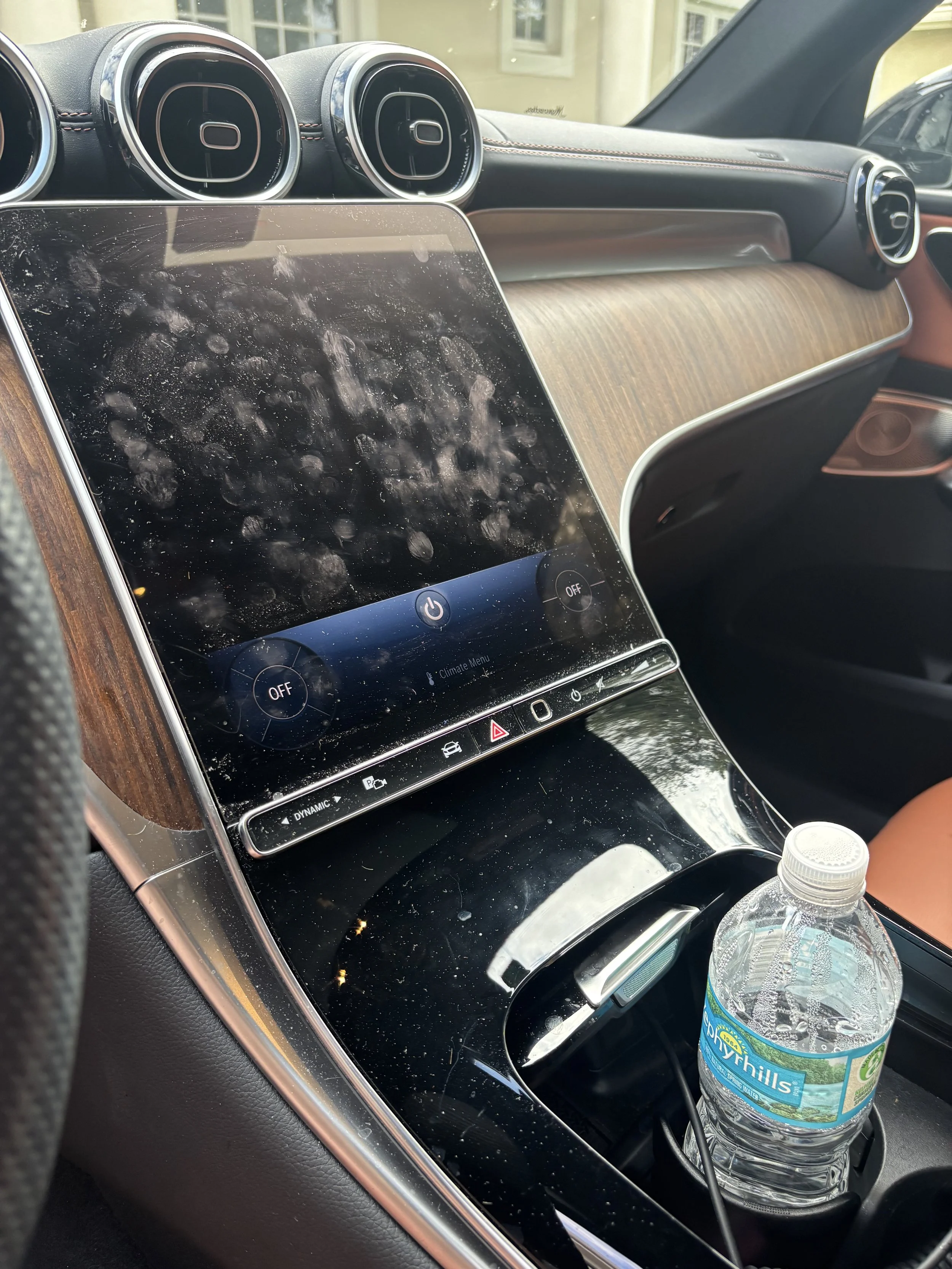 Luxury SUV center console before detailing with fingerprints and dust on infotainment screen in Naples Florida