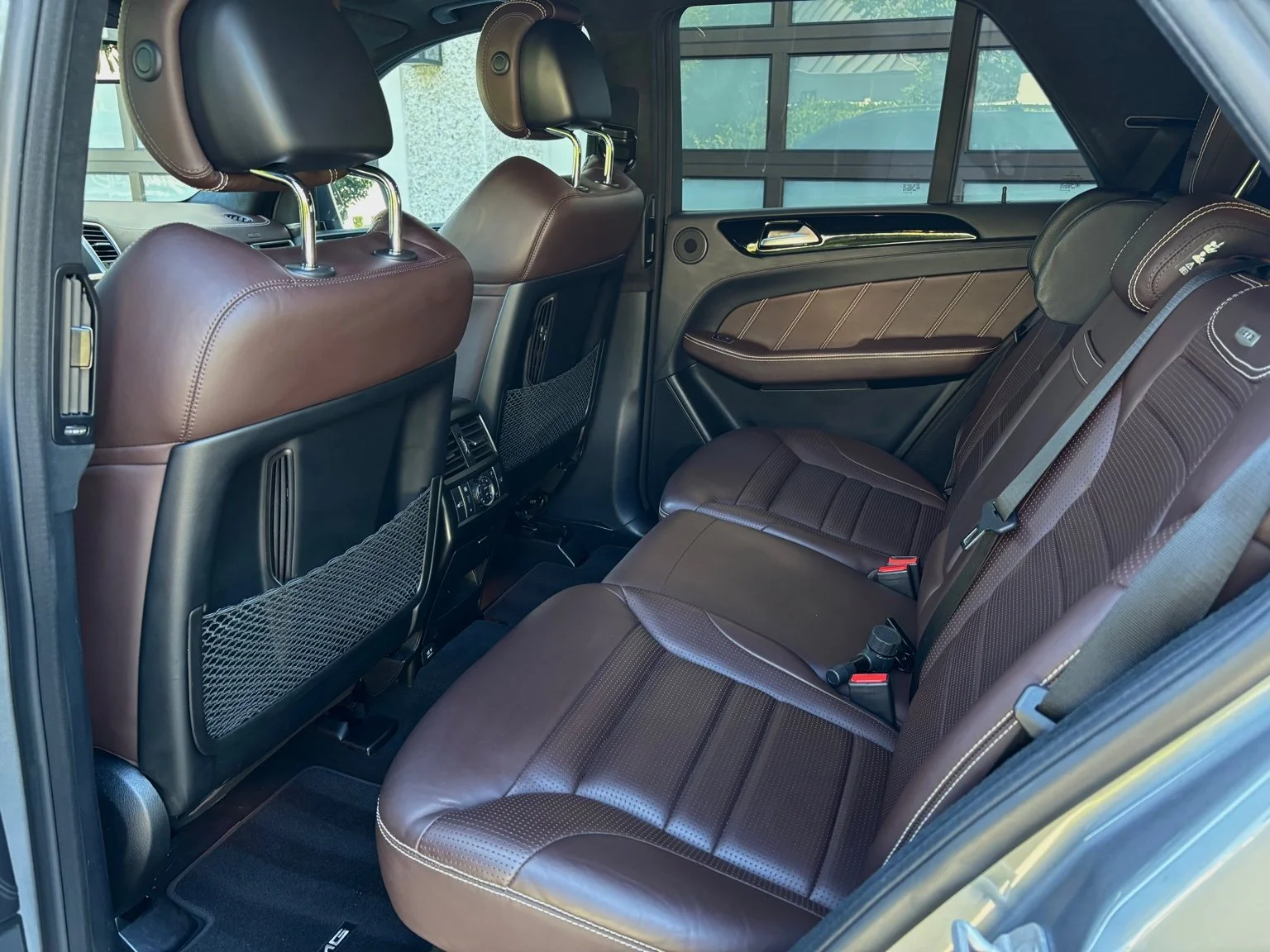 Rear seats after full interior car detailing service in North Naples FL with cleaned brown leather and detailed door panels