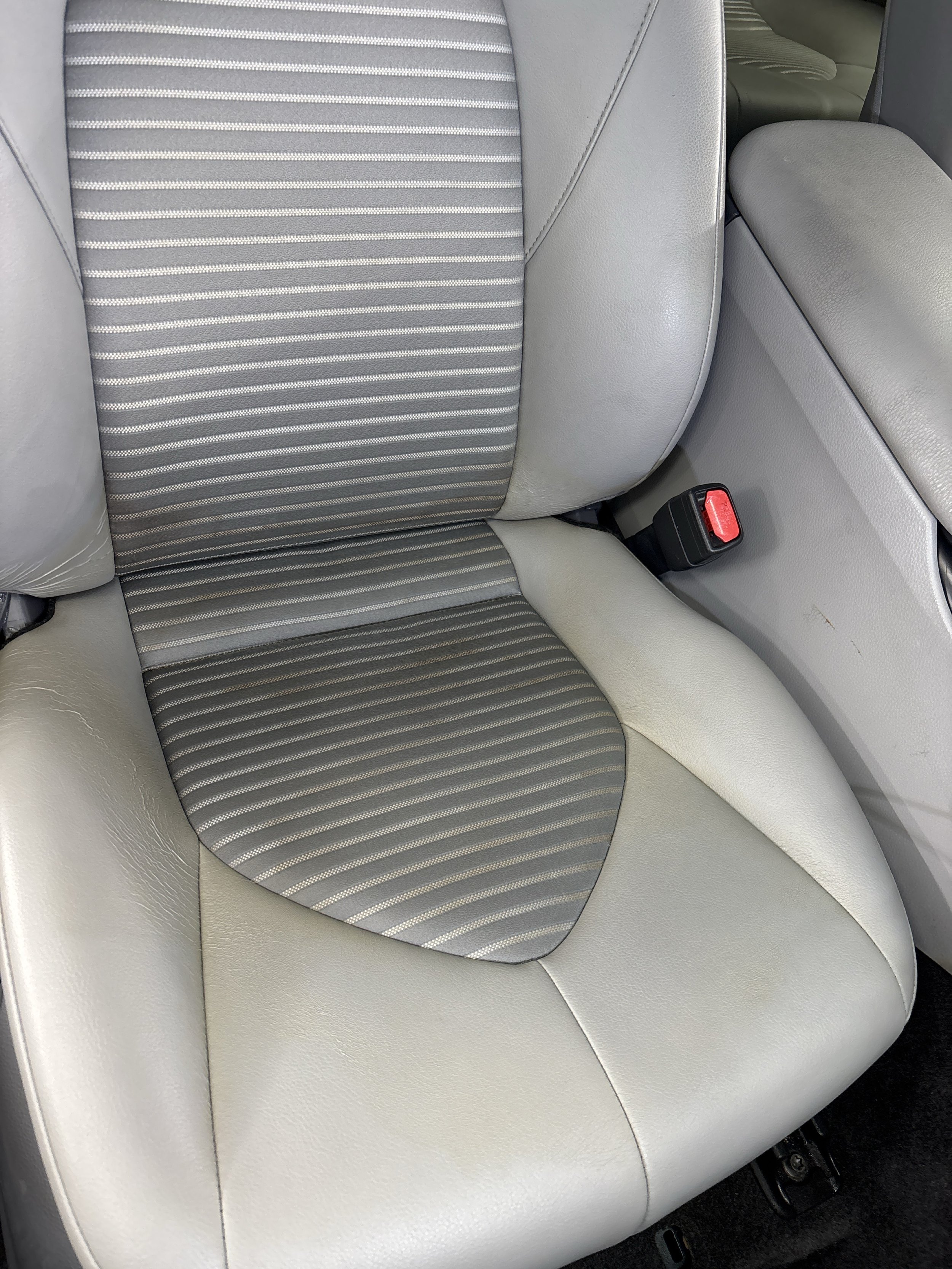 Light leather car seat after professional detailing with restored finish and even tone in Naples FL