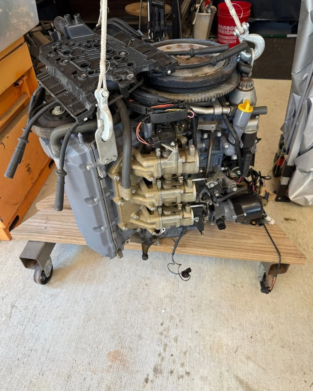 A boat engine on a wooden workbench in a workshop.