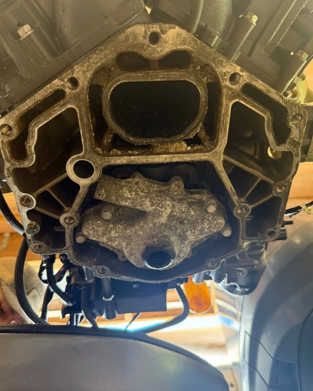 Close-up view of the bottom of a motorcycle engine with stripped-down components, showing the engine casing and internal parts.