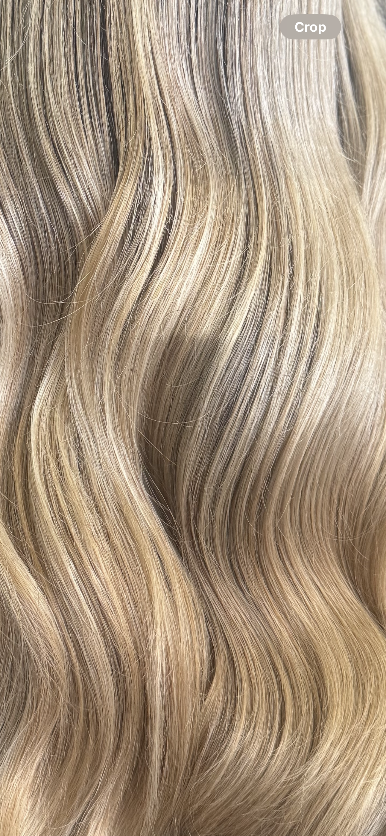 Close-up of wavy blonde hair with highlights.