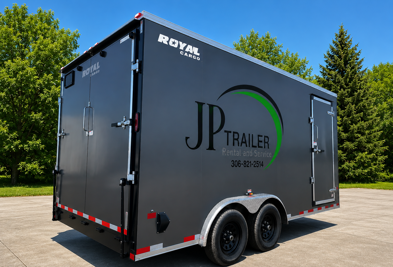A black enclosed trailer parked on a concrete surface with green trees in the background and a clear blue sky. The trailer has the branding 'JP Trailer Rental and Service' and contact information, with the label 'Royal Cargo' at the top corner.