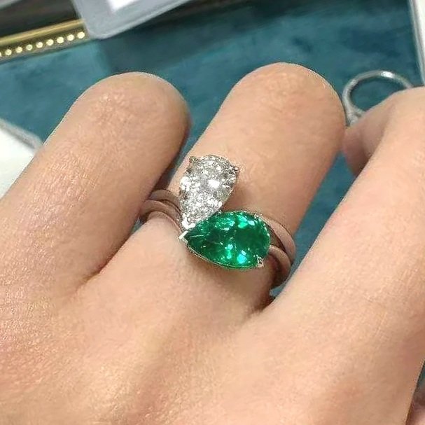 A Toi et Moi ring on a person's finger: with 2 gems on the same ring.