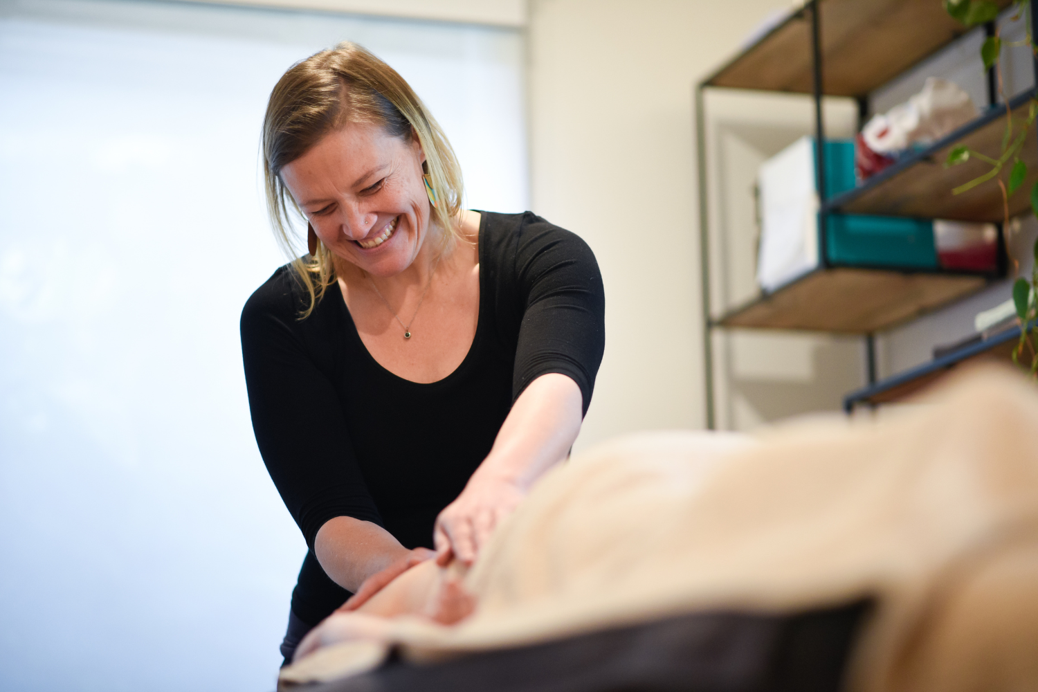 Autumn Ryan Holistic OM Remedial Massage Therapist Massaging a patient with a smile at Ocean Grove