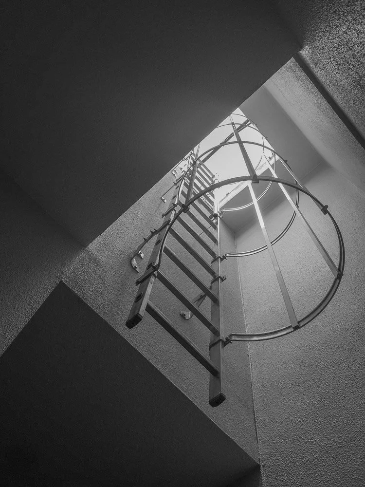 Échelle en métal suspendue au plafond avec la lumière naturelle provenant d'une fenêtre en haut à Toulouse