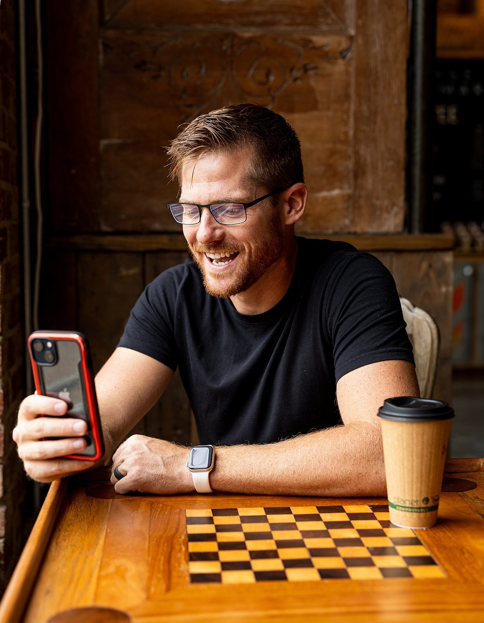 Professional at coffee shop checking messages between networking meetings