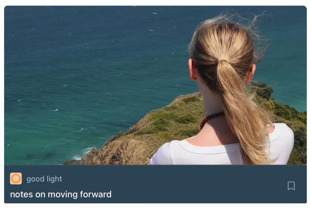 A woman with blonde hair tied back in a ponytail looking out over a coastal landscape with water and green cliffs.