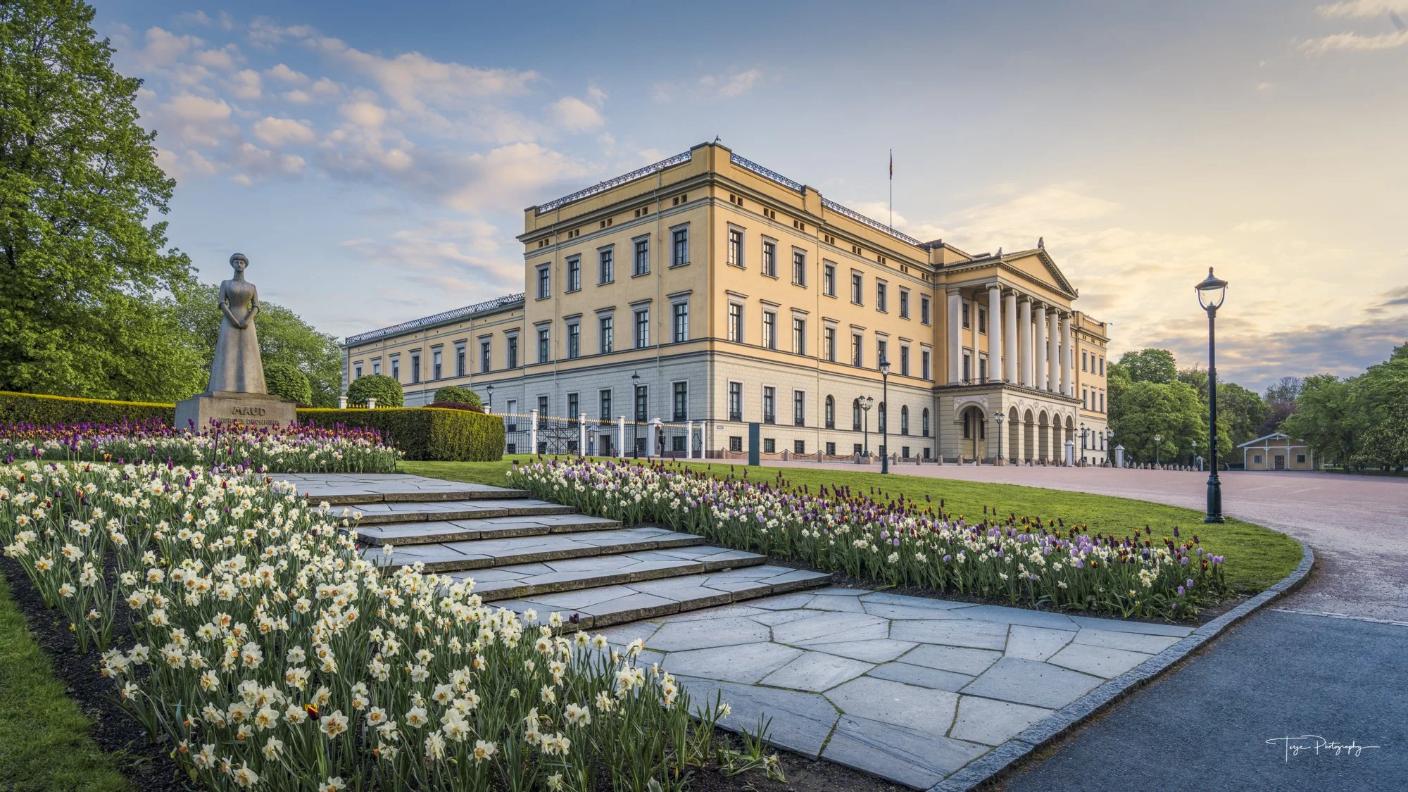 Oslo Royal Palace photographed from a low angle with flowers and foreground steps for depth.