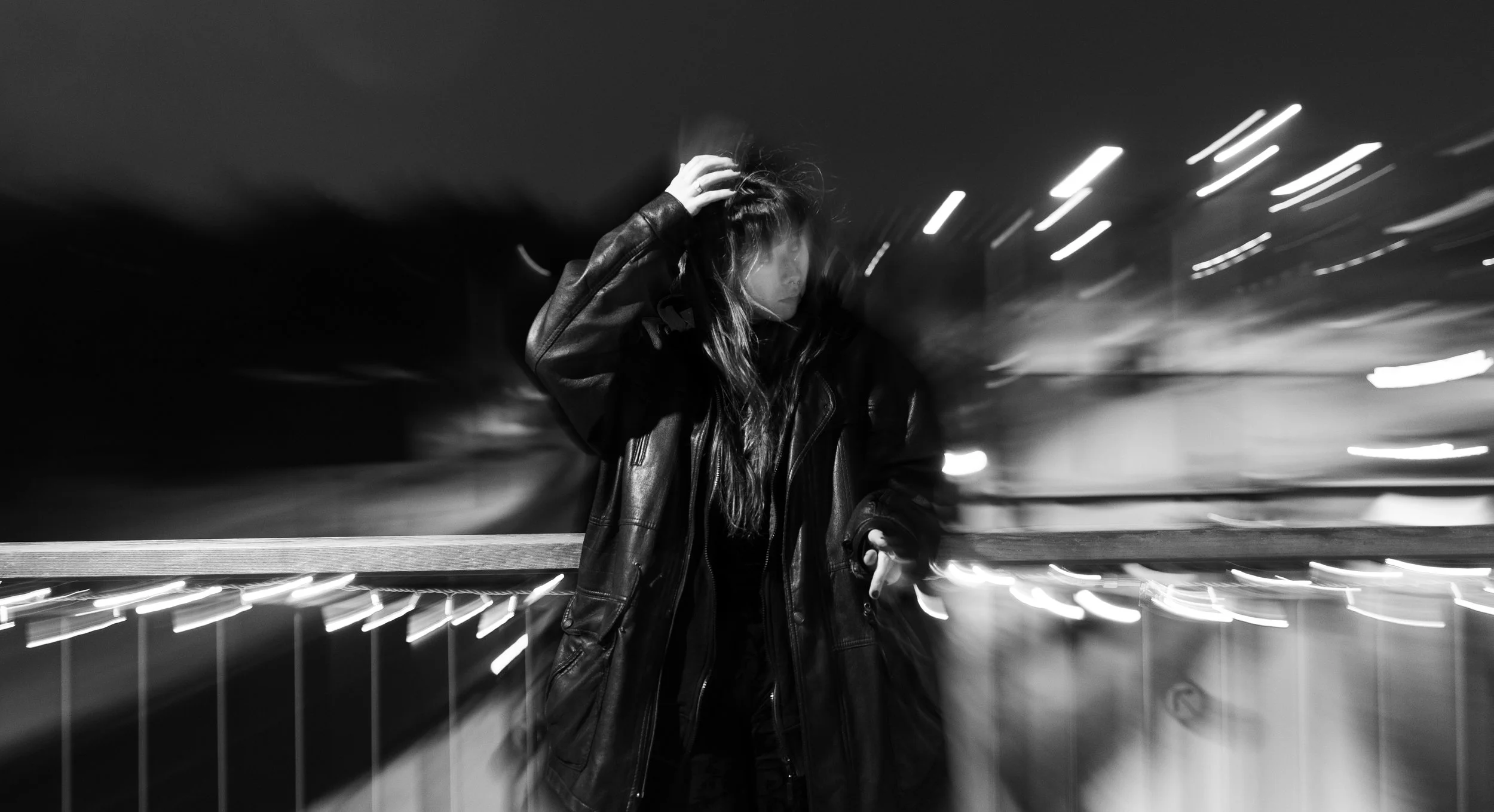 Music artist Maaria standing on a bridge.