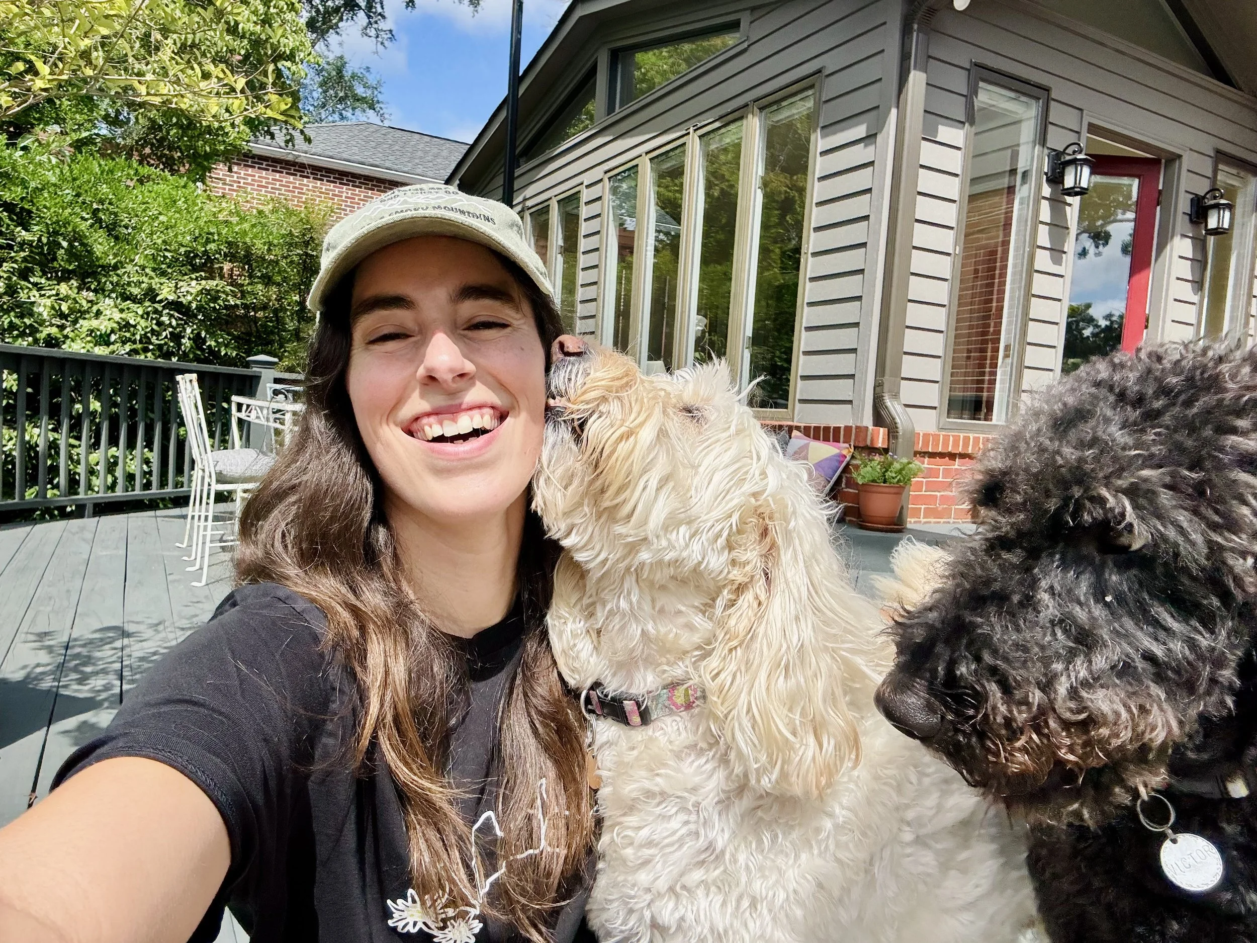 Megan sitting with a dog on the back porch