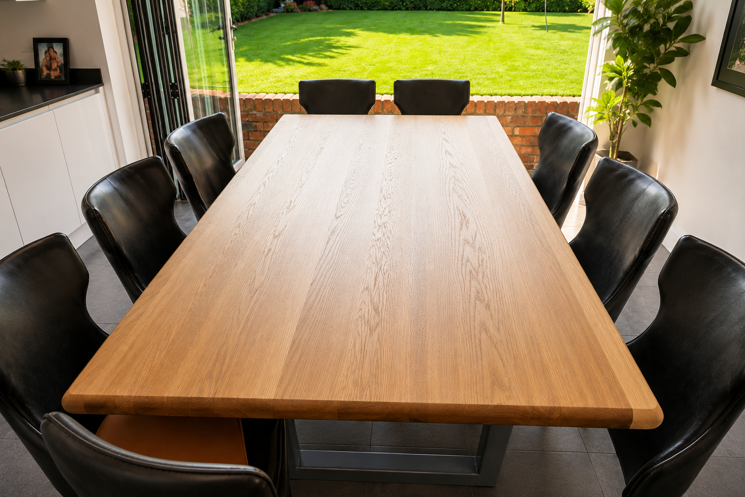 Handcrafted solid white oak dining table with natural finish and modern steel legs, made by Earthworm Fine Woodworking in Devon.