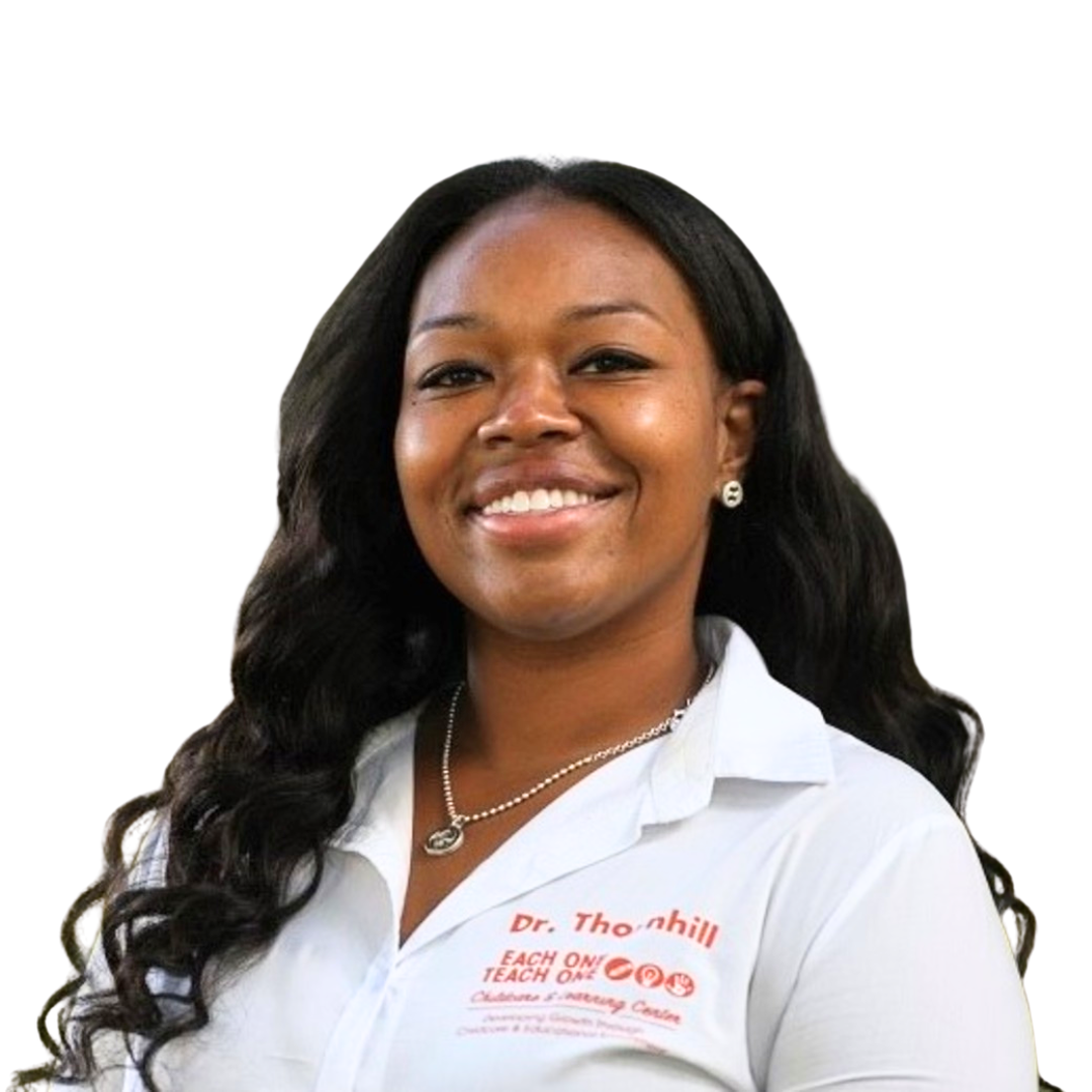 Dr. Dominique Thornhill smiling wearing a white button down shirt with Dr. Thornhill and the Each One Teach One logo on it.