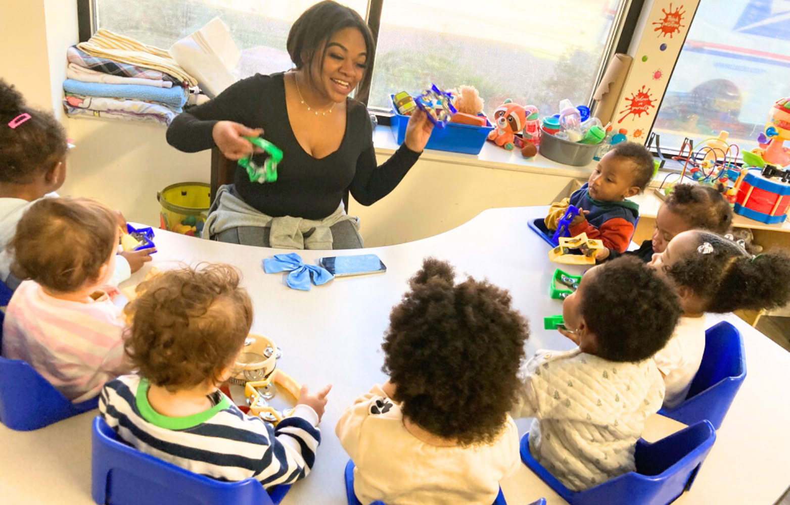 Our toddler 1 teacher is holding star tambourines