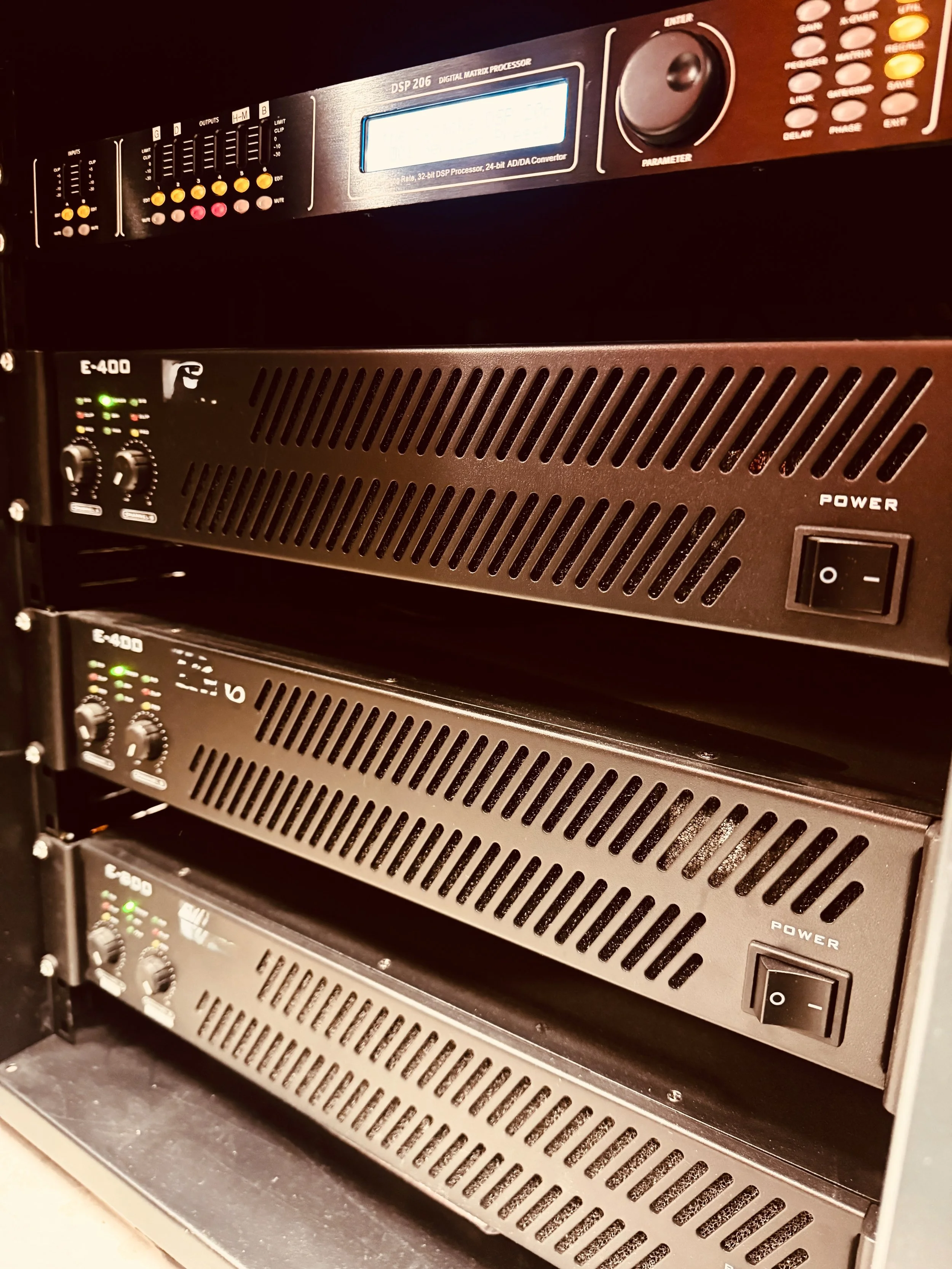 Une unité de traitement audio avec plusieurs amplificateurs et équipements électroniques dans une armoire de serveur.